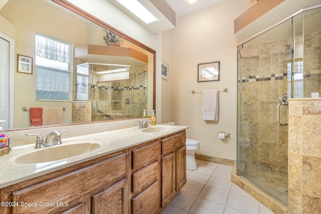 bathroom featuring tile patterned flooring, vanity, a shower with door, and toilet