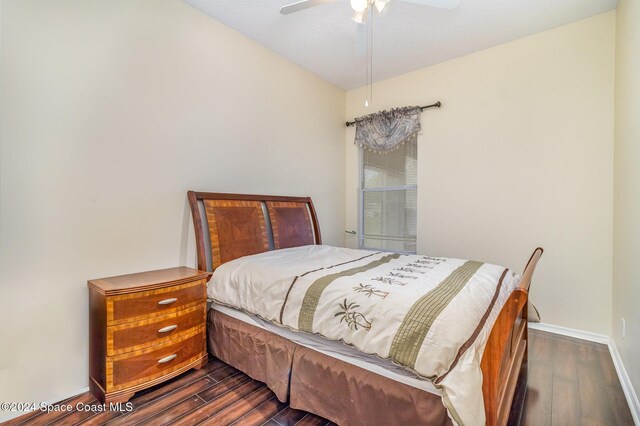 bedroom with ceiling fan, dark hardwood / wood-style floors, and a textured ceiling