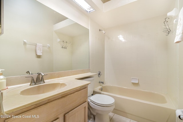 full bathroom with tile patterned floors, vanity, tiled shower / bath, and toilet