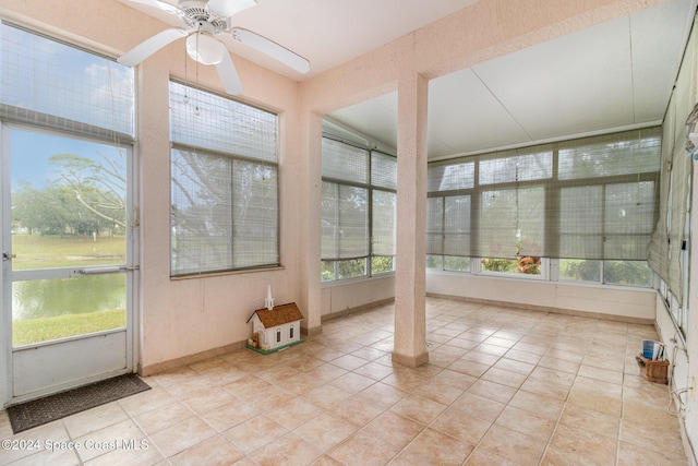 unfurnished sunroom featuring ceiling fan