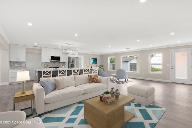 living room featuring light hardwood / wood-style floors and crown molding