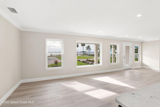 spare room featuring ornamental molding and light wood-type flooring