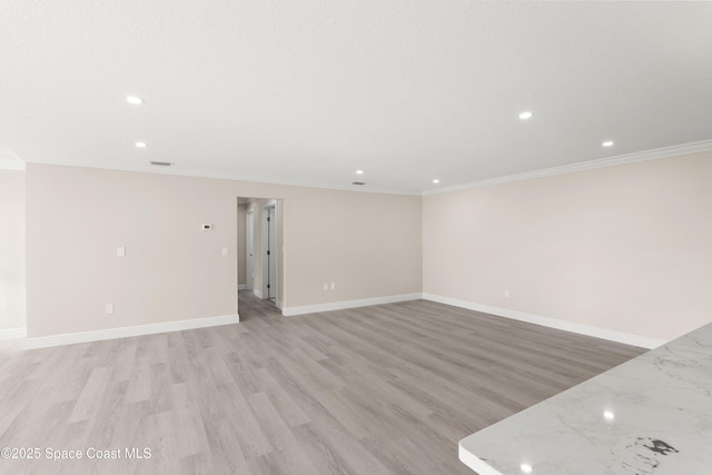 empty room with light hardwood / wood-style flooring and ornamental molding