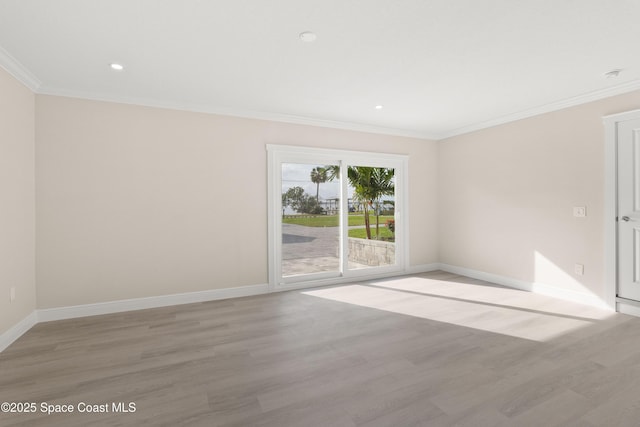 empty room with ornamental molding and light wood-type flooring