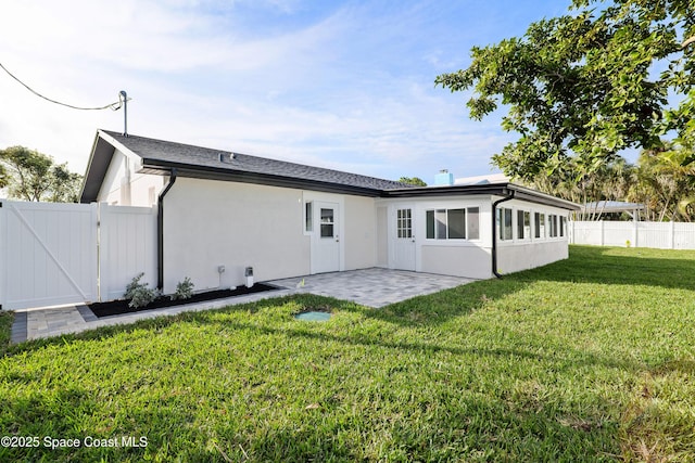 back of property with a yard and a patio