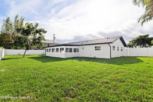 rear view of property featuring a lawn