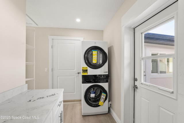 washroom featuring light hardwood / wood-style flooring and stacked washer / drying machine