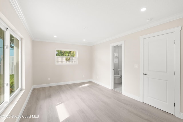 empty room featuring ornamental molding and light hardwood / wood-style flooring