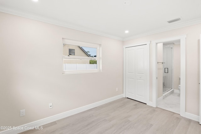 unfurnished bedroom featuring connected bathroom, light hardwood / wood-style floors, a closet, and crown molding