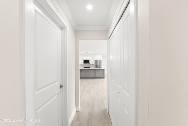 hall with crown molding and light hardwood / wood-style flooring