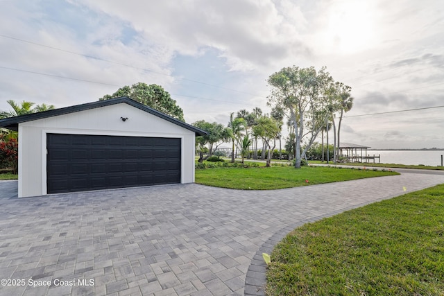 garage with a lawn and a water view