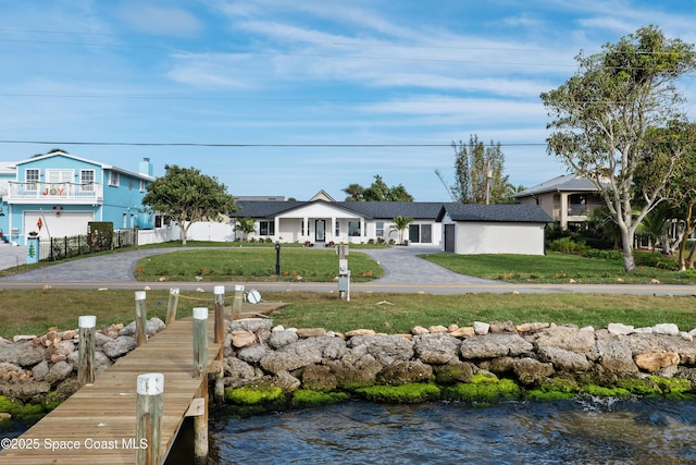 view of front of home featuring a water view and a front lawn