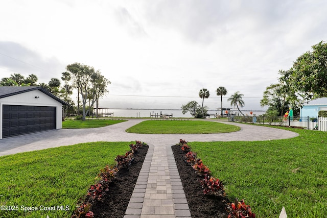 view of yard featuring a water view and a garage