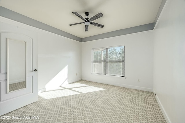 carpeted spare room with ceiling fan