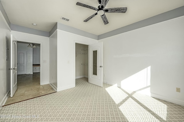 unfurnished bedroom featuring ceiling fan, light colored carpet, and a closet