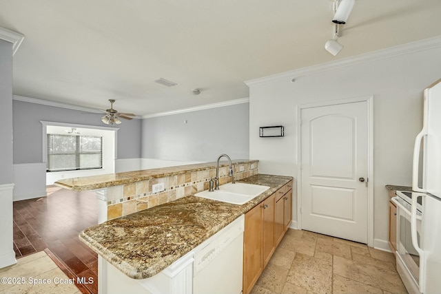 kitchen featuring ceiling fan, sink, kitchen peninsula, white appliances, and decorative backsplash