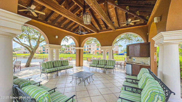 view of patio featuring an outdoor hangout area, a water view, ceiling fan, and sink