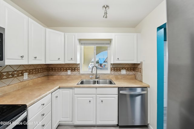 kitchen featuring backsplash, white cabinetry, dishwasher, and sink