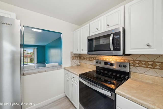 kitchen with backsplash, white cabinetry, and appliances with stainless steel finishes