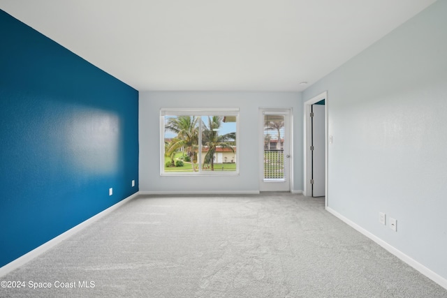 unfurnished room featuring light carpet