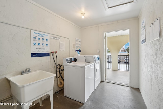 clothes washing area featuring sink, washer and dryer, and ornamental molding