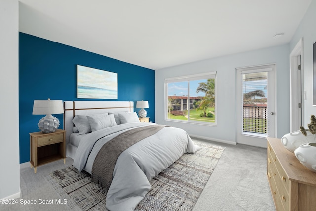 bedroom with access to outside and light colored carpet