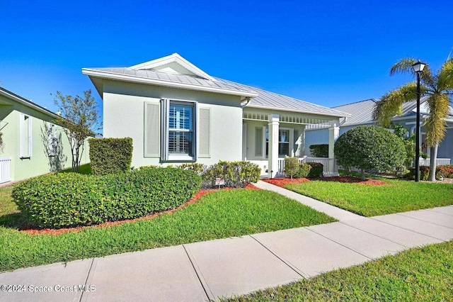 view of front of home featuring covered porch and a front lawn