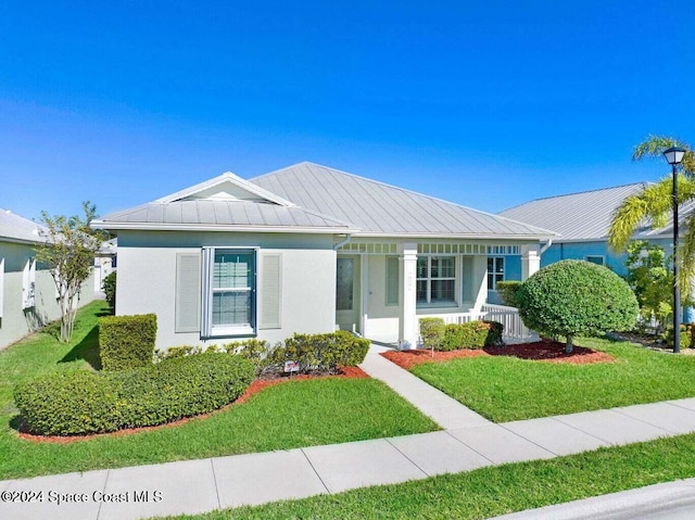 single story home featuring covered porch and a front yard