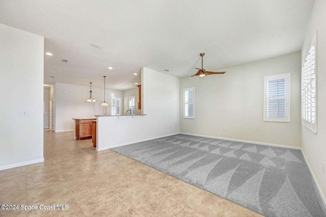 empty room with ceiling fan and light colored carpet