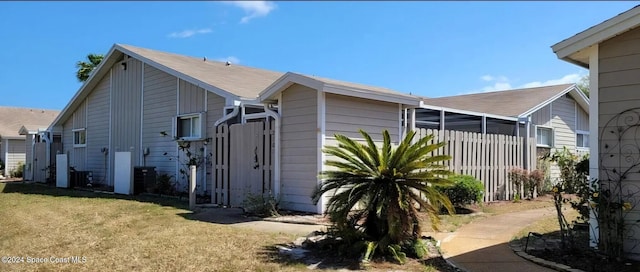 view of home's exterior featuring a lawn and fence