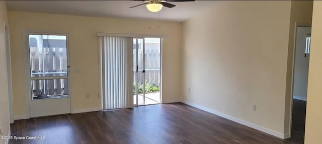 empty room with dark wood finished floors, plenty of natural light, and baseboards