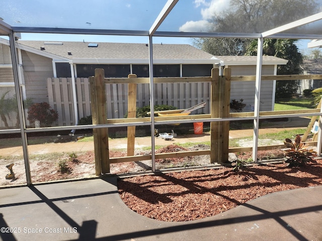 view of yard with glass enclosure and fence