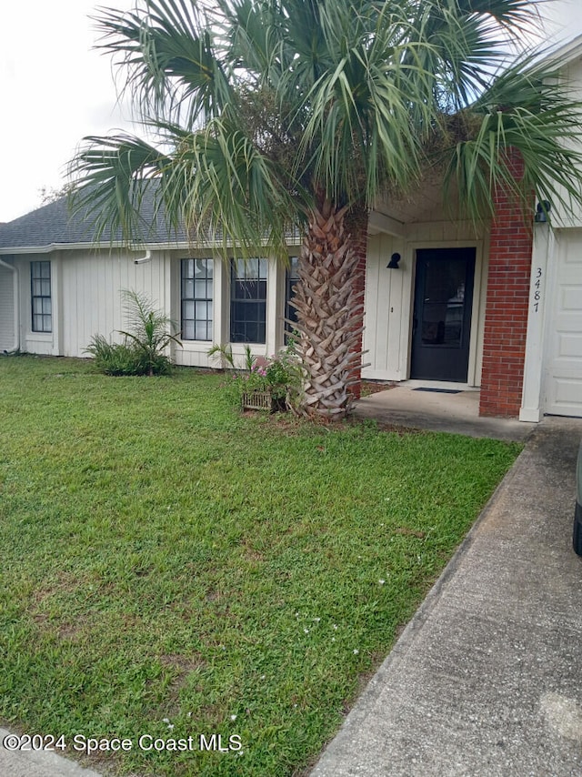 doorway to property with a yard and a garage