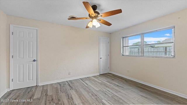 empty room featuring ceiling fan and light hardwood / wood-style flooring