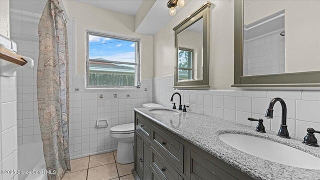 bathroom featuring tile patterned floors, vanity, toilet, and tile walls