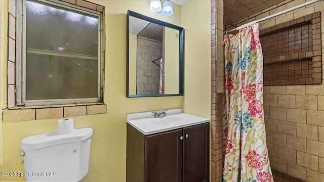 bathroom featuring vanity, curtained shower, and toilet