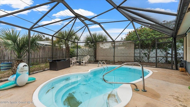 view of swimming pool with glass enclosure and a patio area