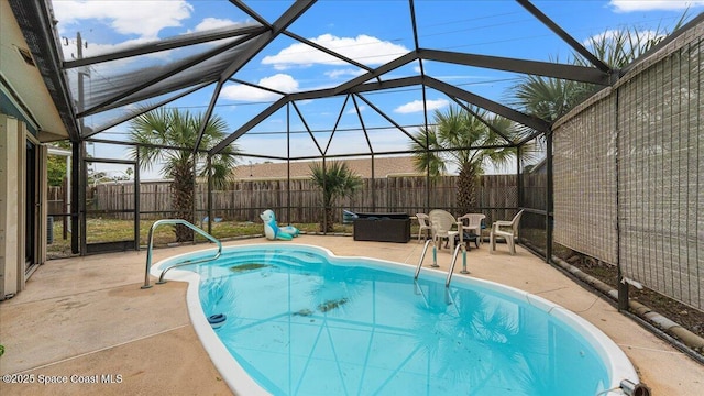 view of swimming pool featuring glass enclosure and a patio area