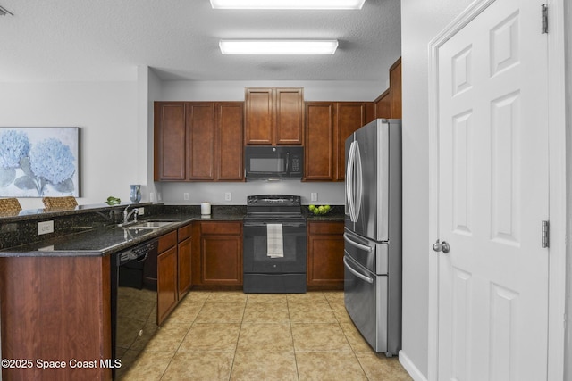 kitchen with sink, dark stone counters, a textured ceiling, light tile patterned floors, and black appliances