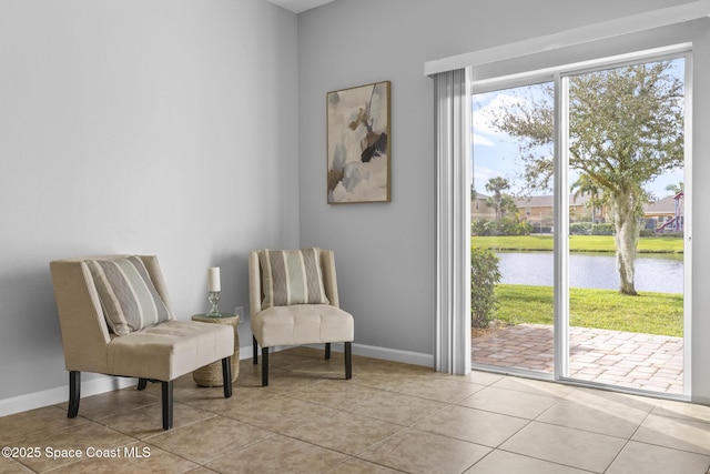 sitting room featuring light tile patterned floors and a water view