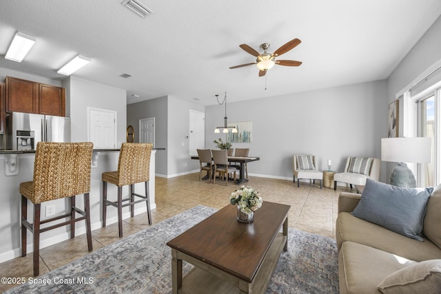 tiled living room with ceiling fan and a textured ceiling