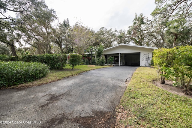 view of front of property with a carport and a front lawn