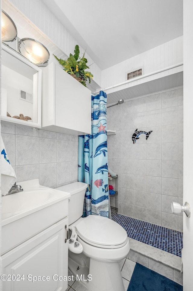 bathroom with tile patterned floors, curtained shower, toilet, and tile walls