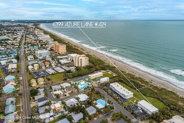 birds eye view of property with a water view and a beach view