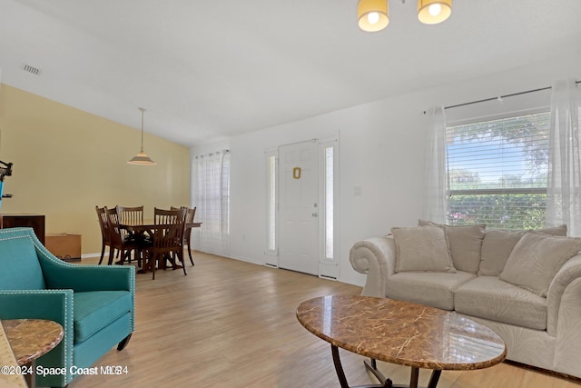 living room with light hardwood / wood-style floors and lofted ceiling