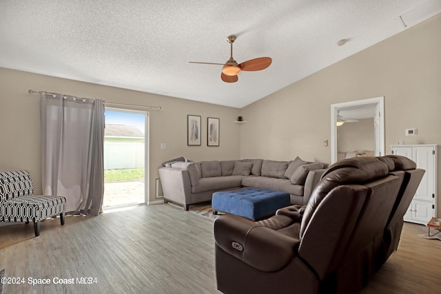 living room featuring hardwood / wood-style floors, a textured ceiling, vaulted ceiling, and ceiling fan