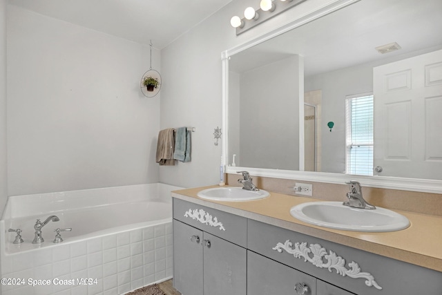 bathroom with vanity and shower with separate bathtub