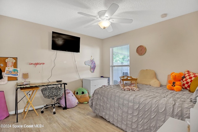 bedroom with a textured ceiling, light hardwood / wood-style floors, and ceiling fan