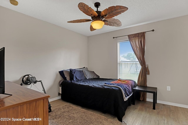 bedroom featuring a textured ceiling, light hardwood / wood-style flooring, and ceiling fan