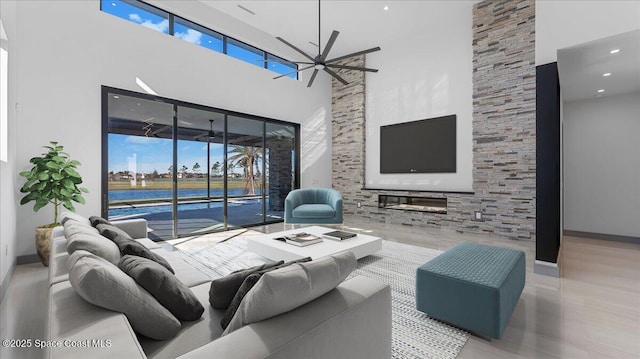 living room featuring a chandelier, a towering ceiling, and a healthy amount of sunlight